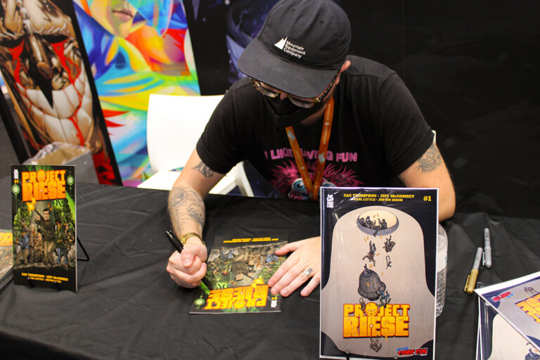 Zac Thompson signing copies of Project Riese at New York Comic Con 2023